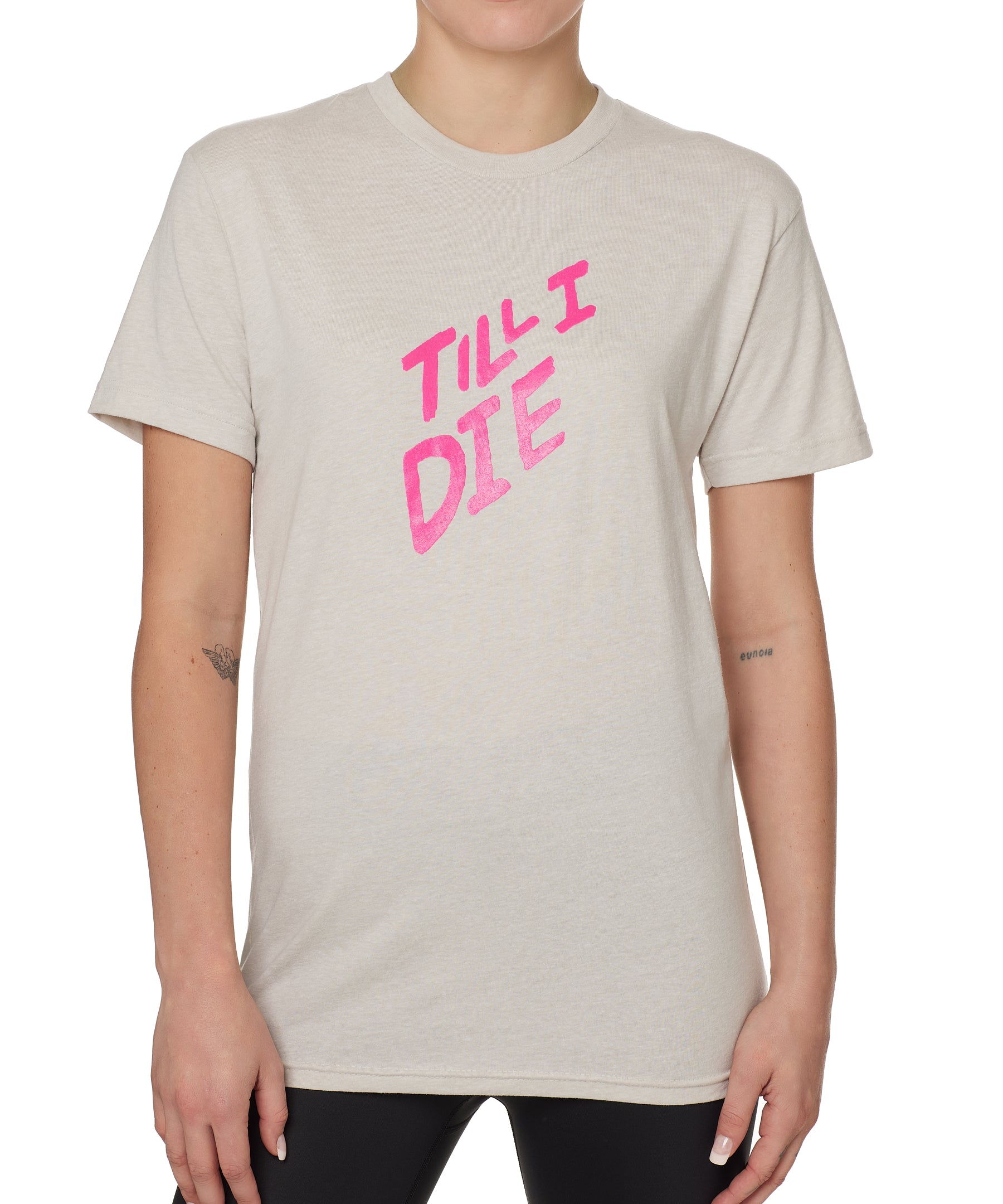 FEMALE MODEL WEARING A TAN TEE SHIRT WITH A THE WORDS TILL I DIE IN NEON PINK