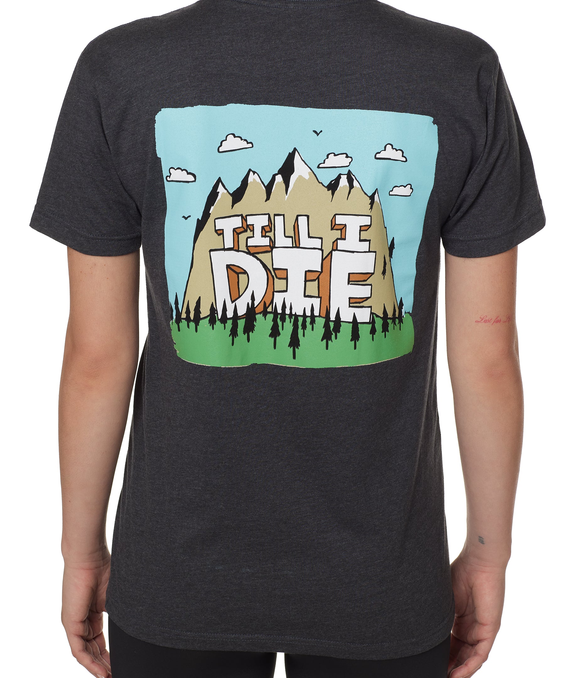 BACK OF A FEMALE MODEL WEARING A HEATHER GRAY TEE SHIRT WITH A GRAPHIC OF A MOUNTAIN AND THE WORDS TILL I DIE