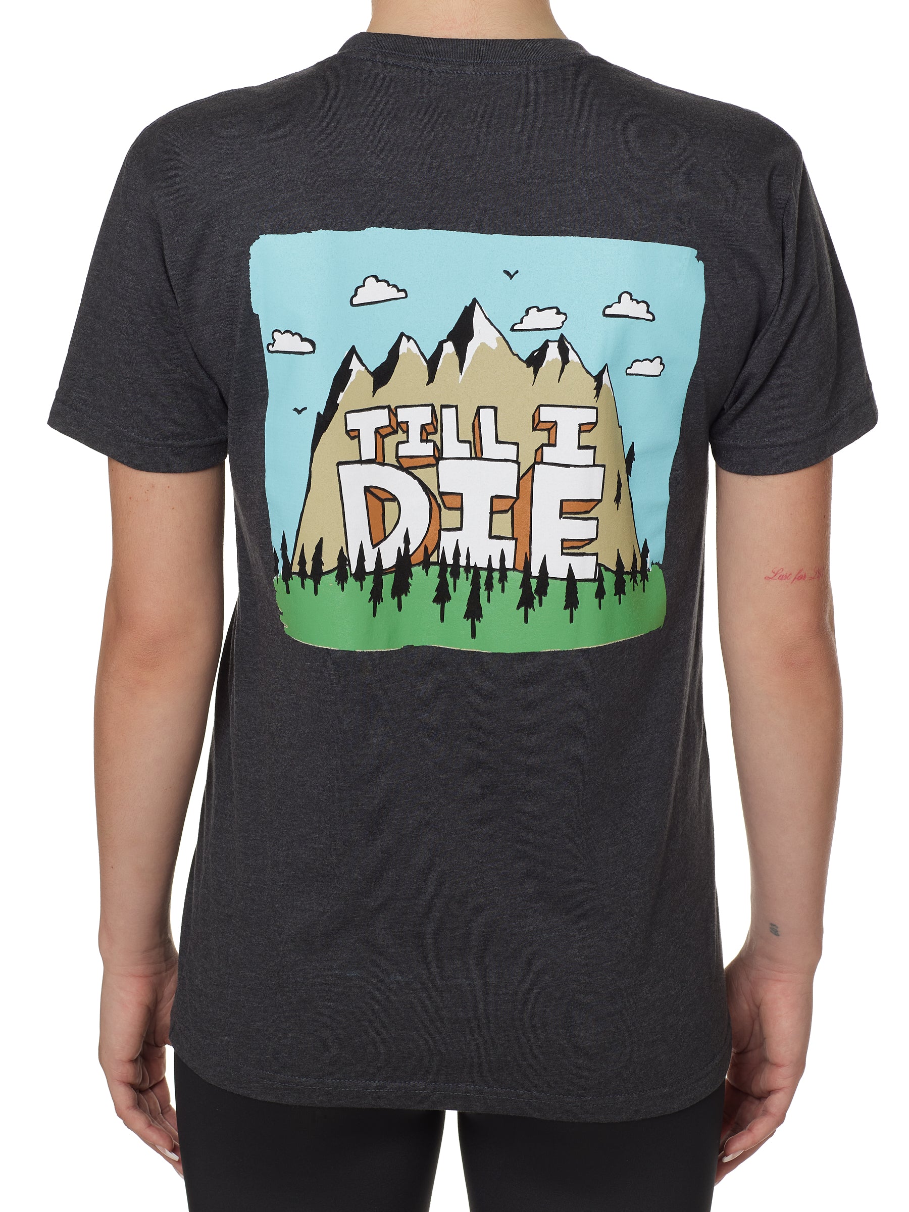 BACK OF A FEMALE MODEL WEARING A HEATHER GRAY TEE SHIRT WITH A GRAPHIC OF A MOUNTAIN AND THE WORDS TILL I DIE