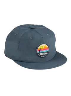 Front view of the Sunset sessions Till I Die vintage blue-colored surf hat on a white background, featuring a multicolored PVC patch with an ocean sunset and palm tree scene, anchored by “Till I Die” text along the bottom.