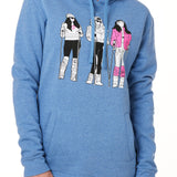 FEMALE MODEL WEARING A HEATHER BLUE HOODIE WITH A GRAPHIC OF THREE 1980S SKI LADIES 