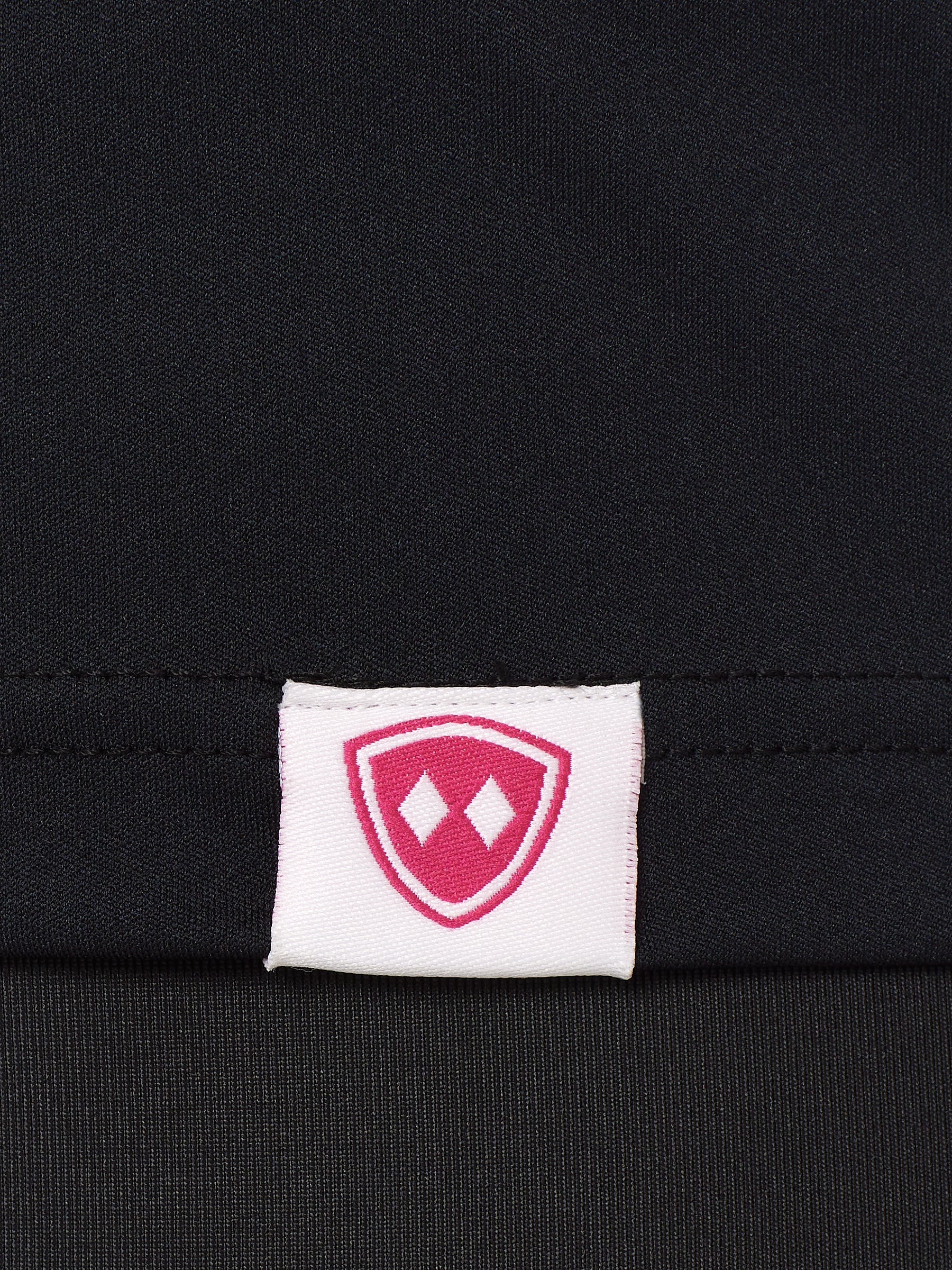 DETAIL OF A BLACK SHIRT WITH A TILL I DIE WOVEN HEM TAG