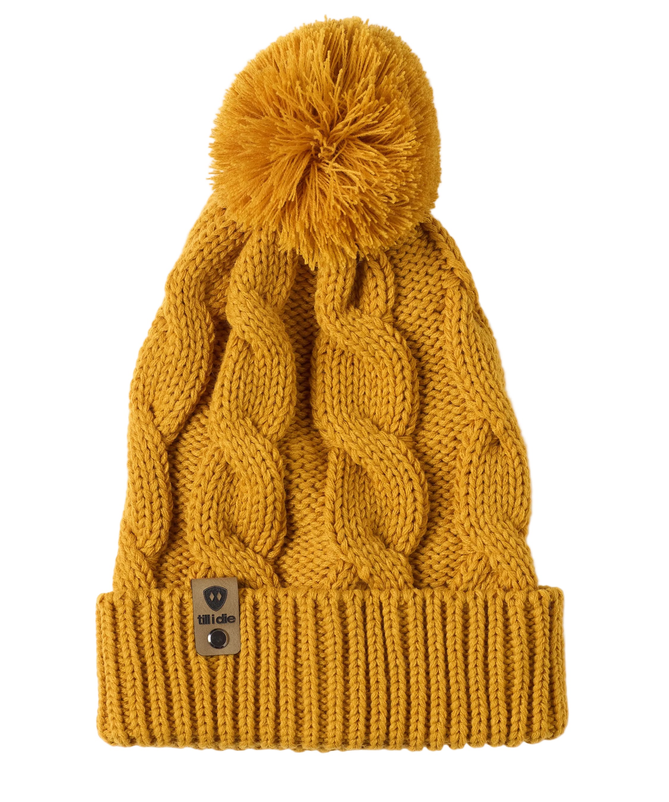 A mustard cable-knit beanie hat with a matching pom-pom on top and a ribbed cuff featuring a Till I Die Logo leather tab, shown against a plain white background.