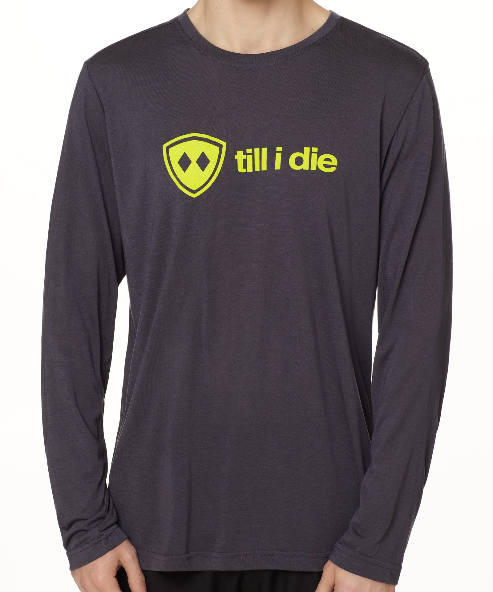 front view of a male model wearing a gray long sleeve tee with a bright yellow till i die logo across the chest