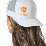 woman wearing backward white trucker hat with neon orange logo