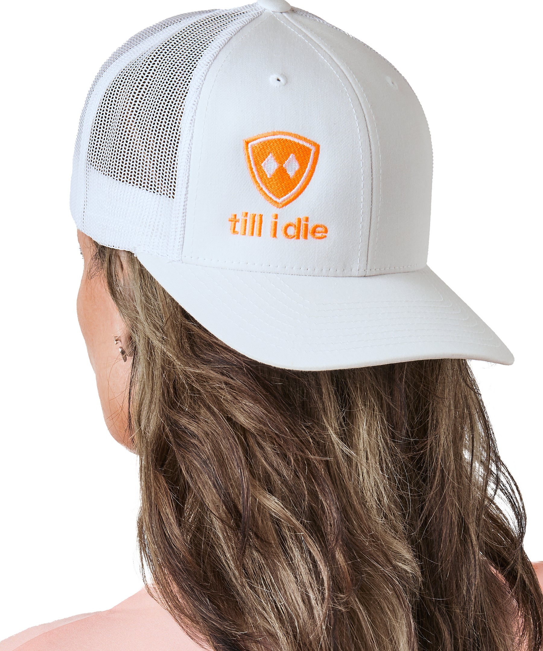 woman wearing backward white trucker hat with neon orange logo