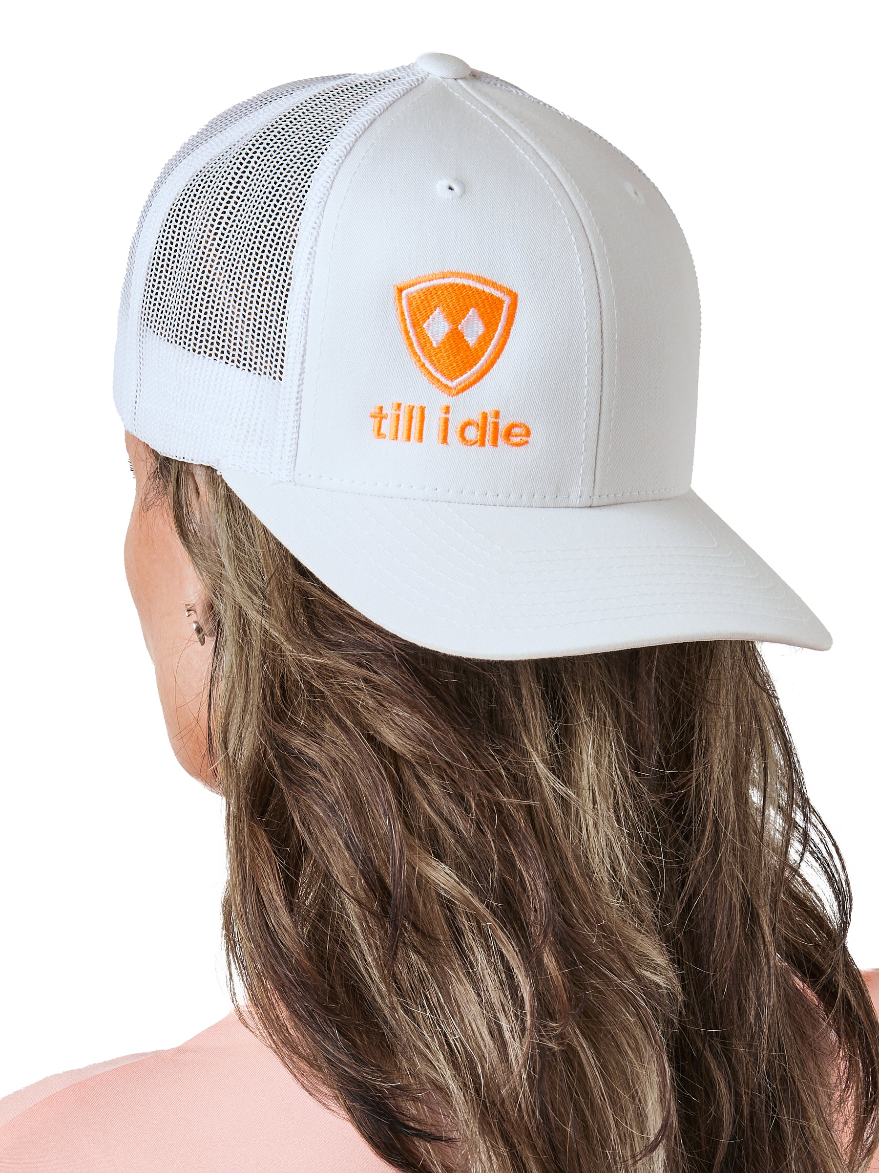 woman wearing backward white trucker hat with neon orange logo