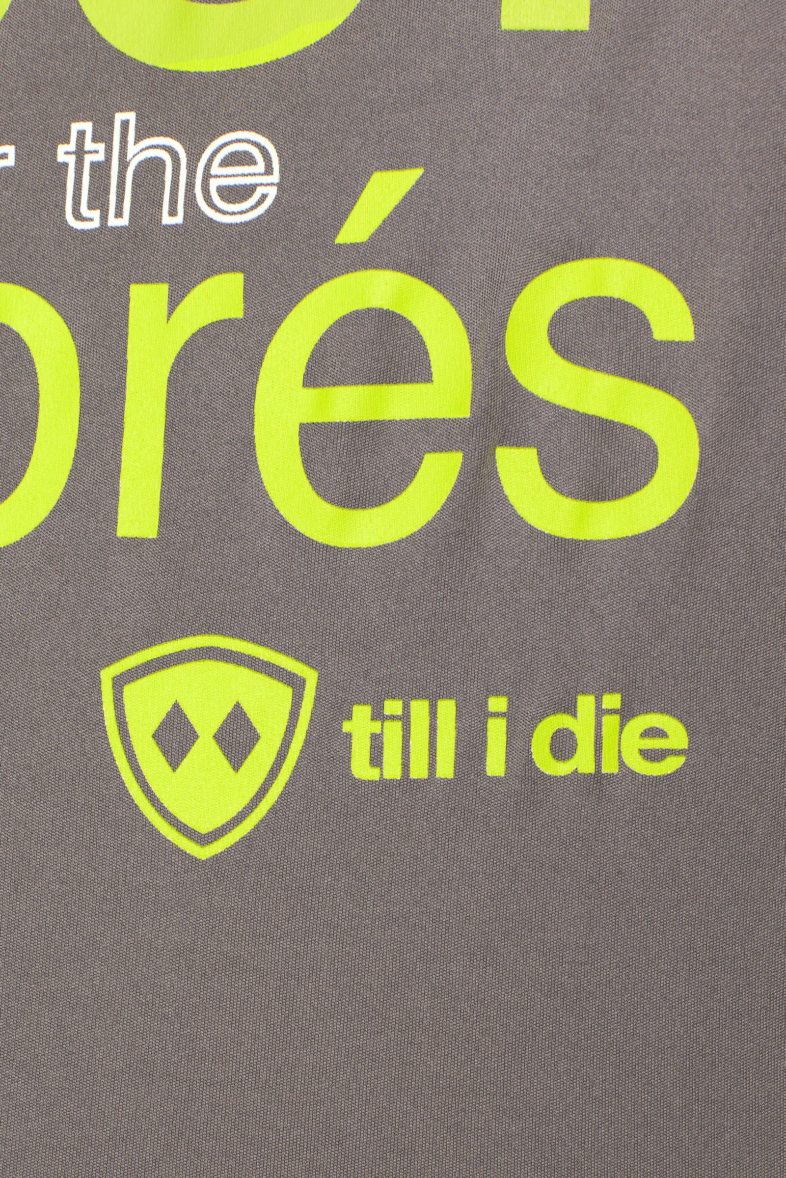 close up detail of the lime green till i die logo on the Aprés shirt