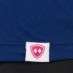 DETAIL OF A BLUE PERFORMANCE SHIRT WITH THE TILL I DIE LOGO HEM TAG