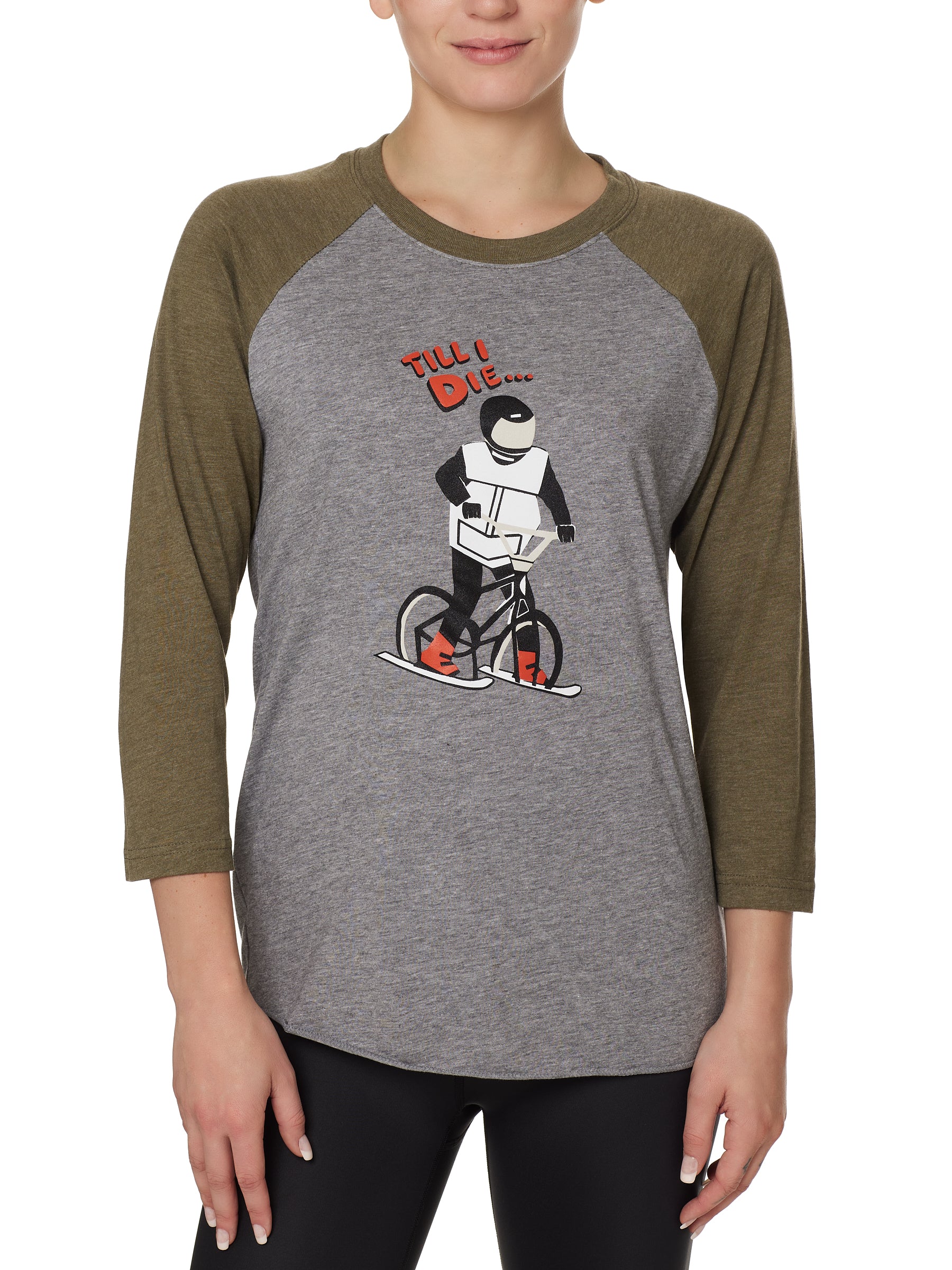 Front view of a female model wearing the Two Dollars Raglan 3/4 sleeve tee. The shirt features military green sleeves and a heather gray body, with a graphic of a ski biker in a full-face helmet. Above the illustration is “Till I Die…” text.