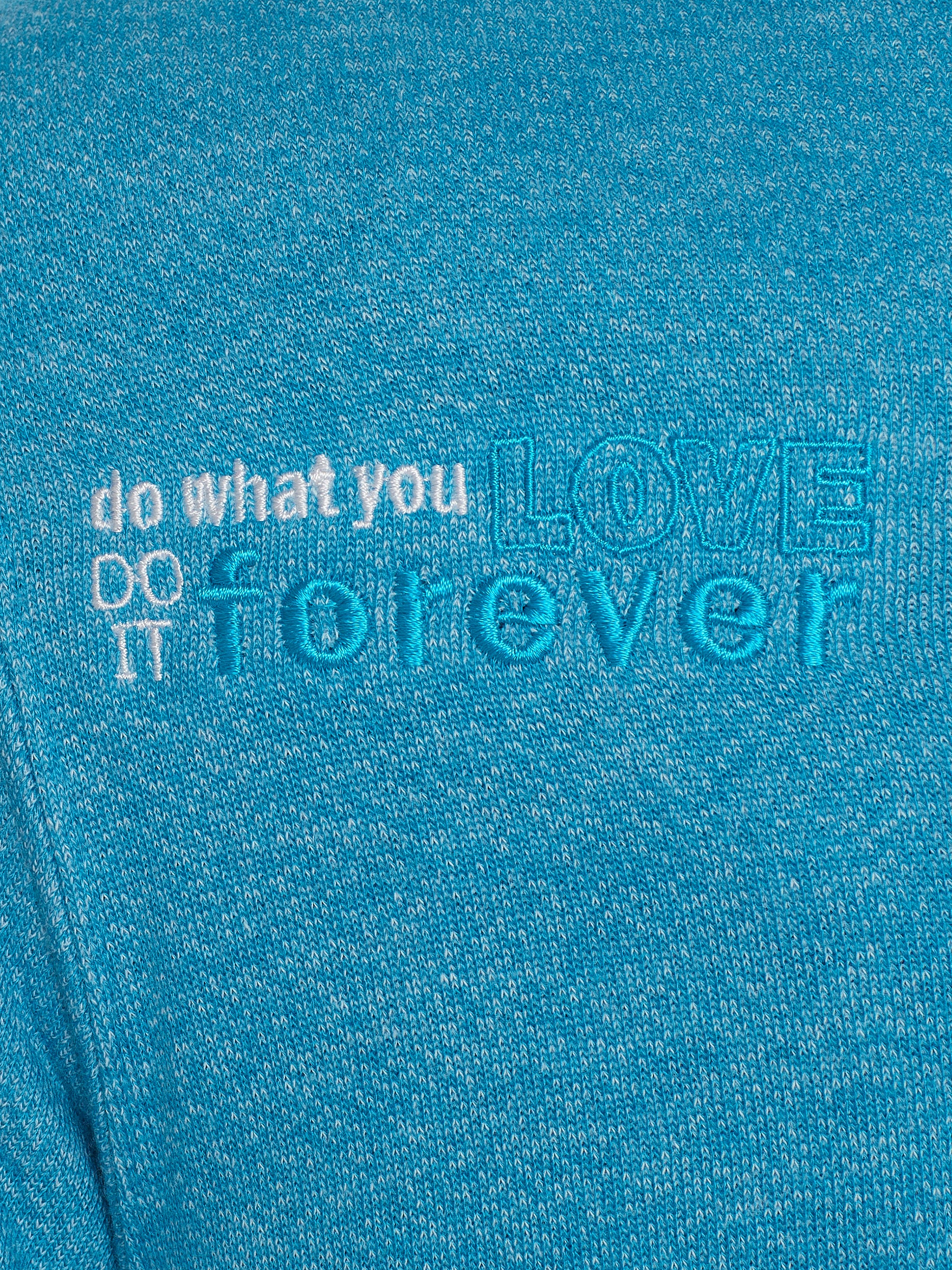 DETAIL OF A HEATHER TEAL HOODIE WITH THE WORDS "DO WHAT YOU LOVE. DO IT FOREVER." EMBROIDERED IN WHITE AND TEAL