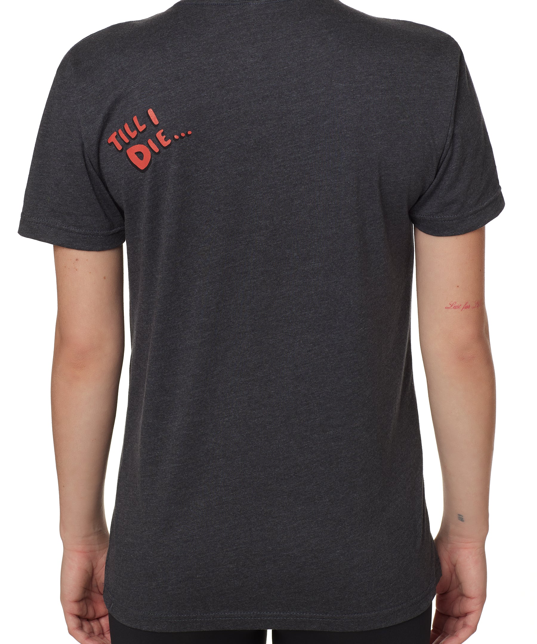 back view of a female wearing a heather slate crew neck tee shirt with a red bubble letter 'till i die'' of wearers top left shoulder 