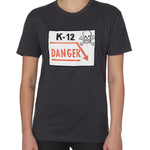 Front view of a female model wearing a gray short-sleeve t-shirt featuring a “K-12 Danger” graphic with a bold skull and crossbones design.