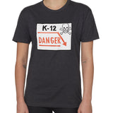 Front view of a female model wearing a gray short-sleeve t-shirt featuring a “K-12 Danger” graphic with a bold skull and crossbones design.