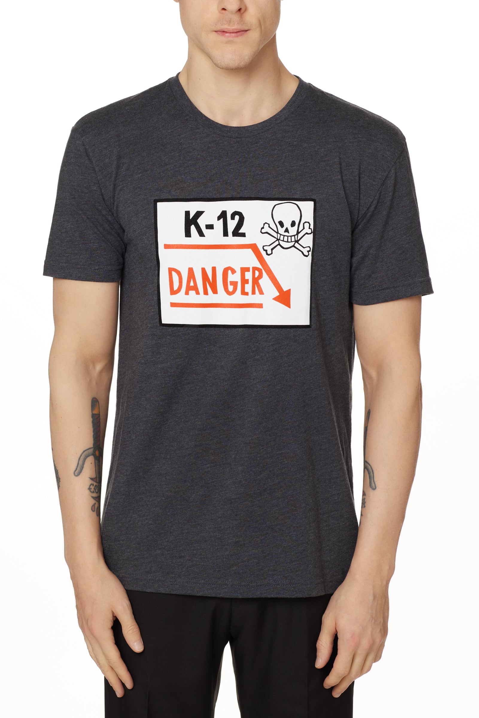 Front view of a male model wearing a gray short-sleeve t-shirt featuring a “K-12 Danger” graphic with a bold skull and crossbones design.