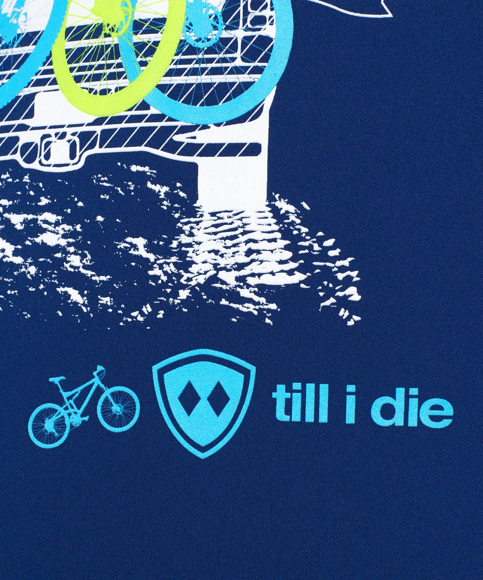 DETAIL OF A BLUE PERFORMANCE SHIRT WITH a light blue TILL I DIE LOGO AND BIKE GRAPHIC