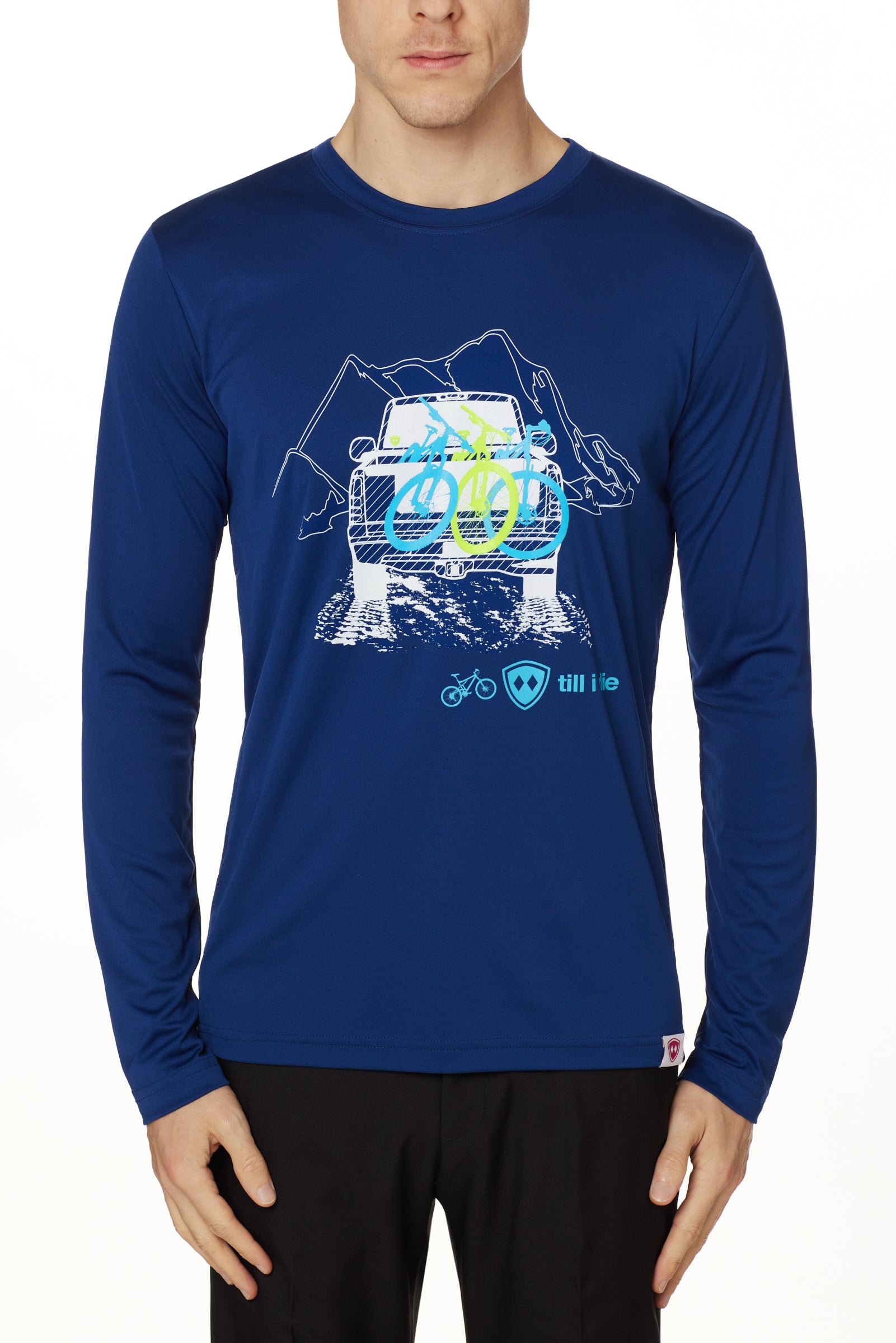 A man wearing a navy blue long sleeve shirt with a graphic print of a truck carrying mountain bikes, and the TILL I DIE LOGO