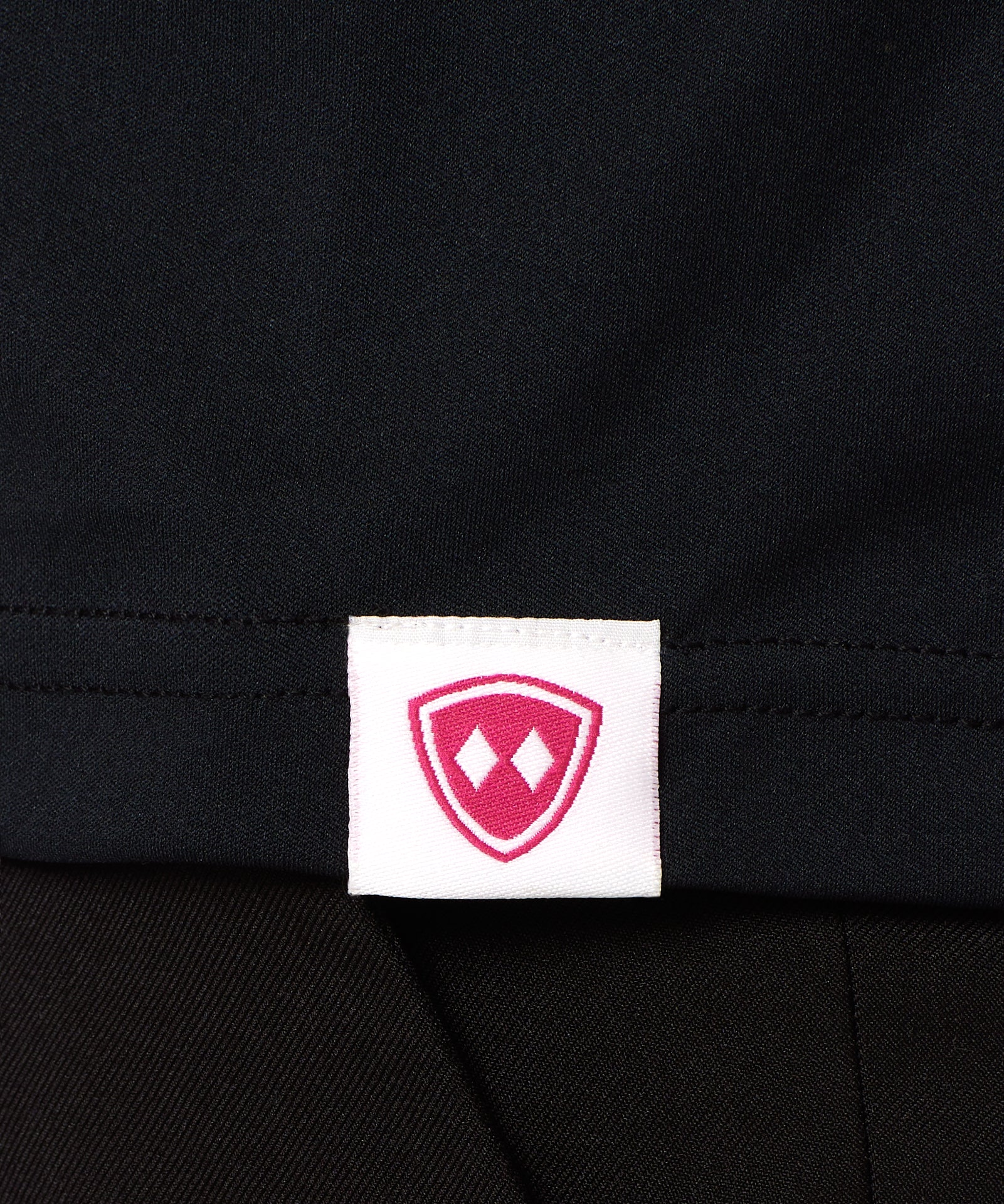 DETAIL OF A BLACK SHIRT WITH THE TILL I DIE LOGO HEM TAG