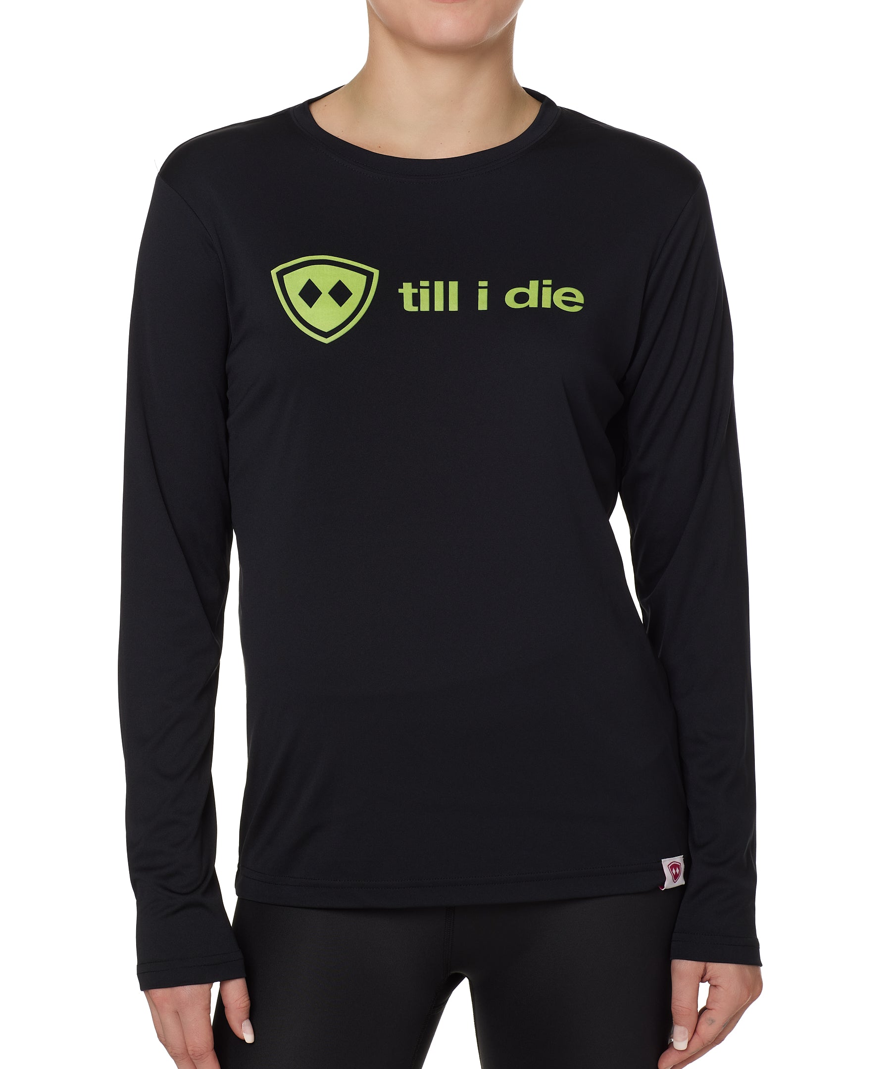 front view of a female model wearing a black long sleeve tee with a bright yellow till i die logo on a white background