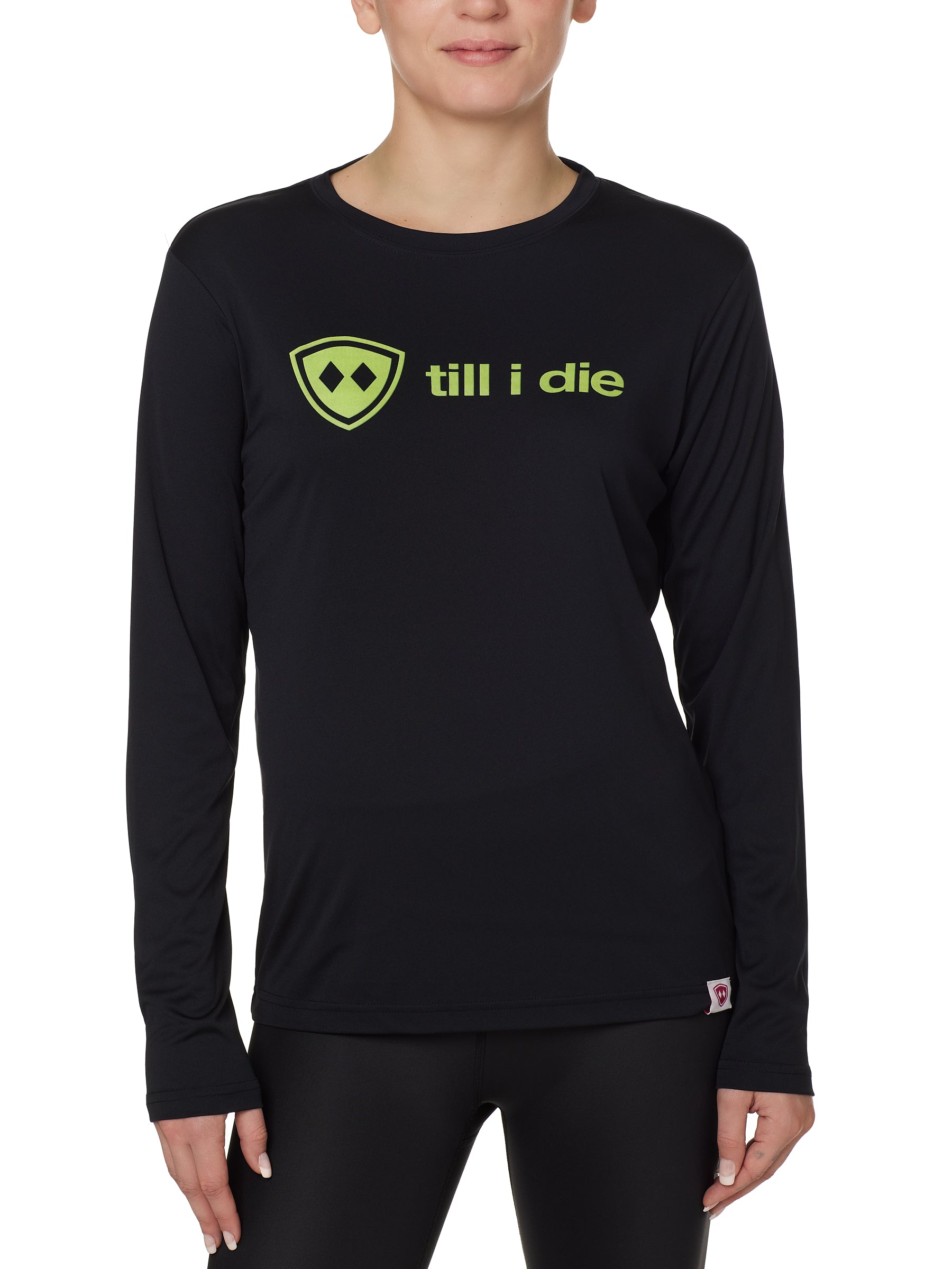 front view of a female model wearing a black long sleeve tee with a bright yellow till i die logo on a white background