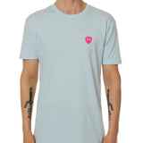 Front view of a male model wearing the Till I Die Bike V-Neck Tee in Light Blue on a white background. The shirt features a pink Double Diamond Shield logo on the wearer's left chest.
