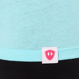 Close-up detail of a pink Double Diamond Shield woven hem label on a Cancun blue tee shirt.
