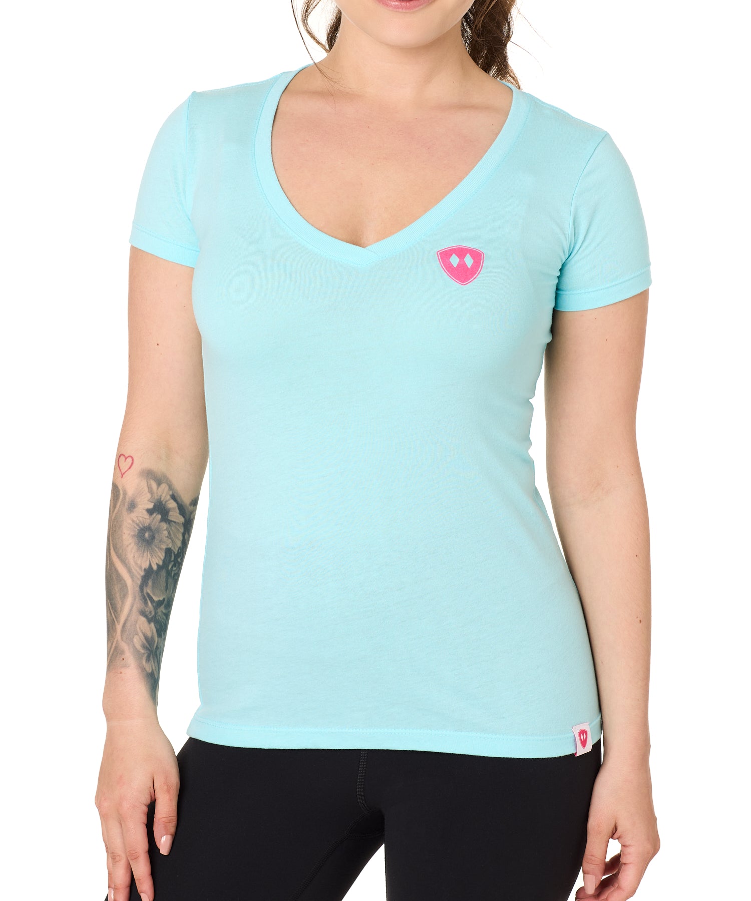 Front view of a female model wearing the Till I Die Bike V-Neck Tee in Cancun Blue on a white background. The shirt features a pink Double Diamond Shield logo on the wearer's left chest.