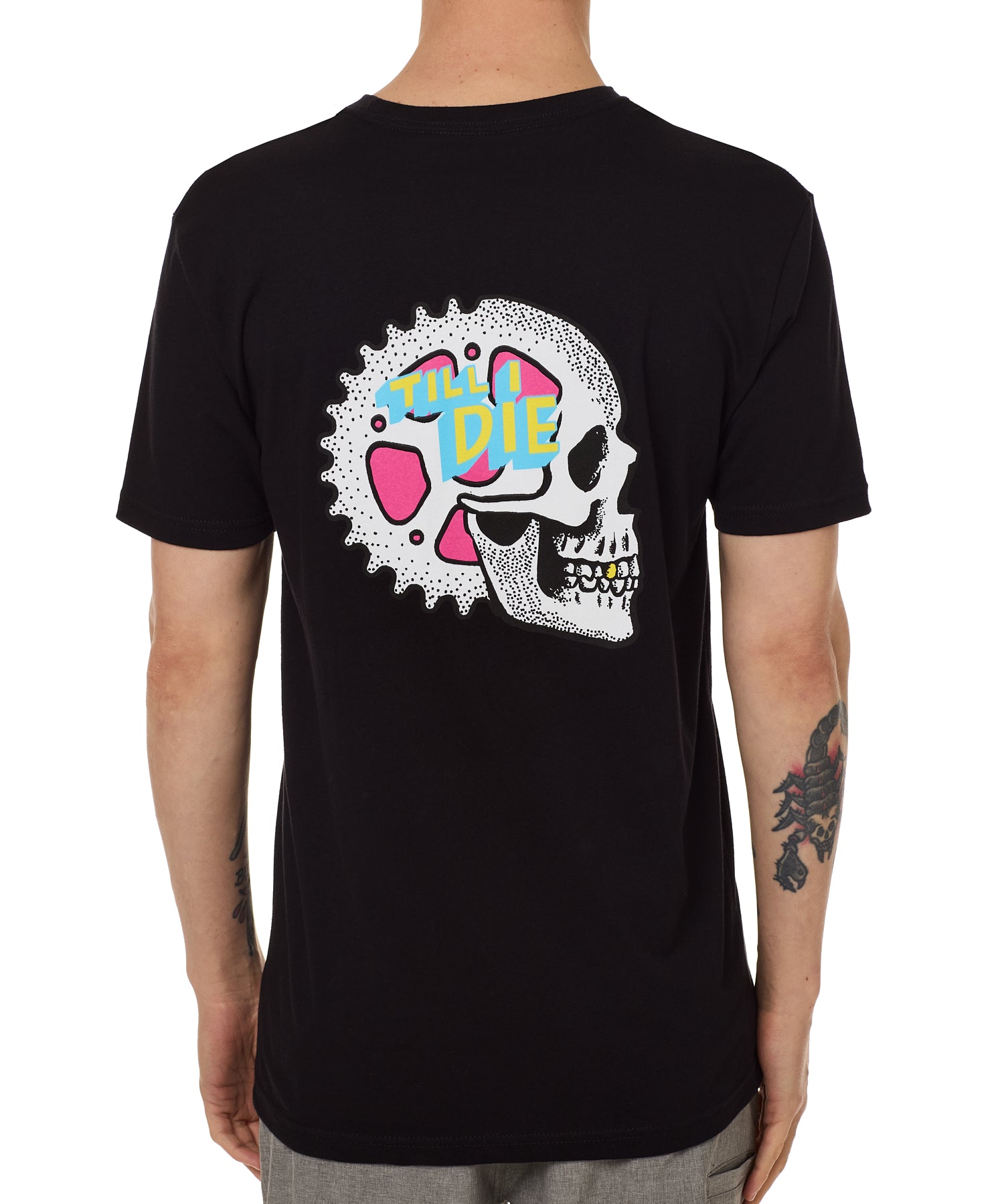 Back view of a male model wearing the Gear Head Tee in black. The back graphic features a skull with gears inside the head and overlapped by yellow and blue "Till I Die" text.