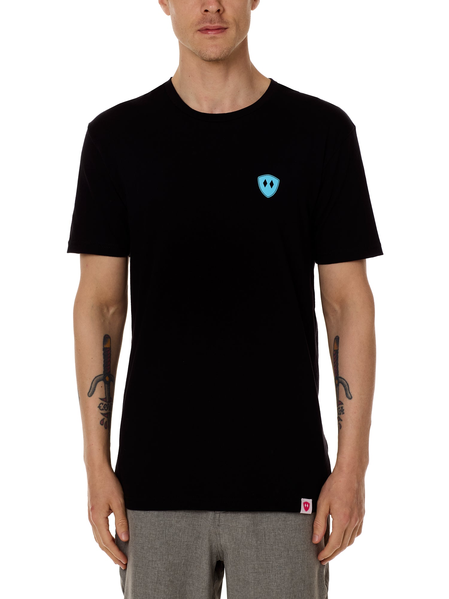 Front view of a male model wearing the Gear Head crew neck tee in black on a white background. Accented with a cyan blue double diamond shield over wearers left chest.