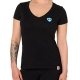 Front view of a female model wearing the Gear Head V neck tee in black on a white background. Accented with a cyan blue double diamond shield over wearers left chest.