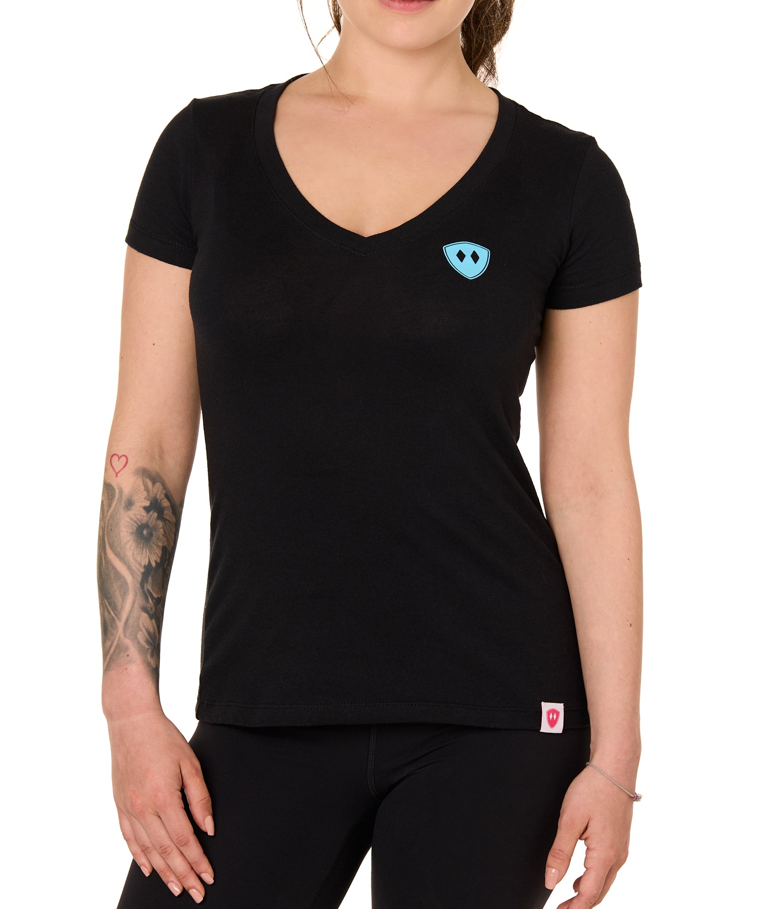 Front view of a female model wearing the Gear Head V neck tee in black on a white background. Accented with a cyan blue double diamond shield over wearers left chest.
