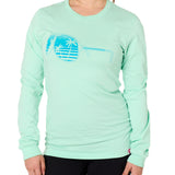 Front view of a female model wearing a long sleeve crew neck Mint Green T-Shirt. The graphic features a blue print of sunglasses with a tropical beach scene reflected in the lenses.