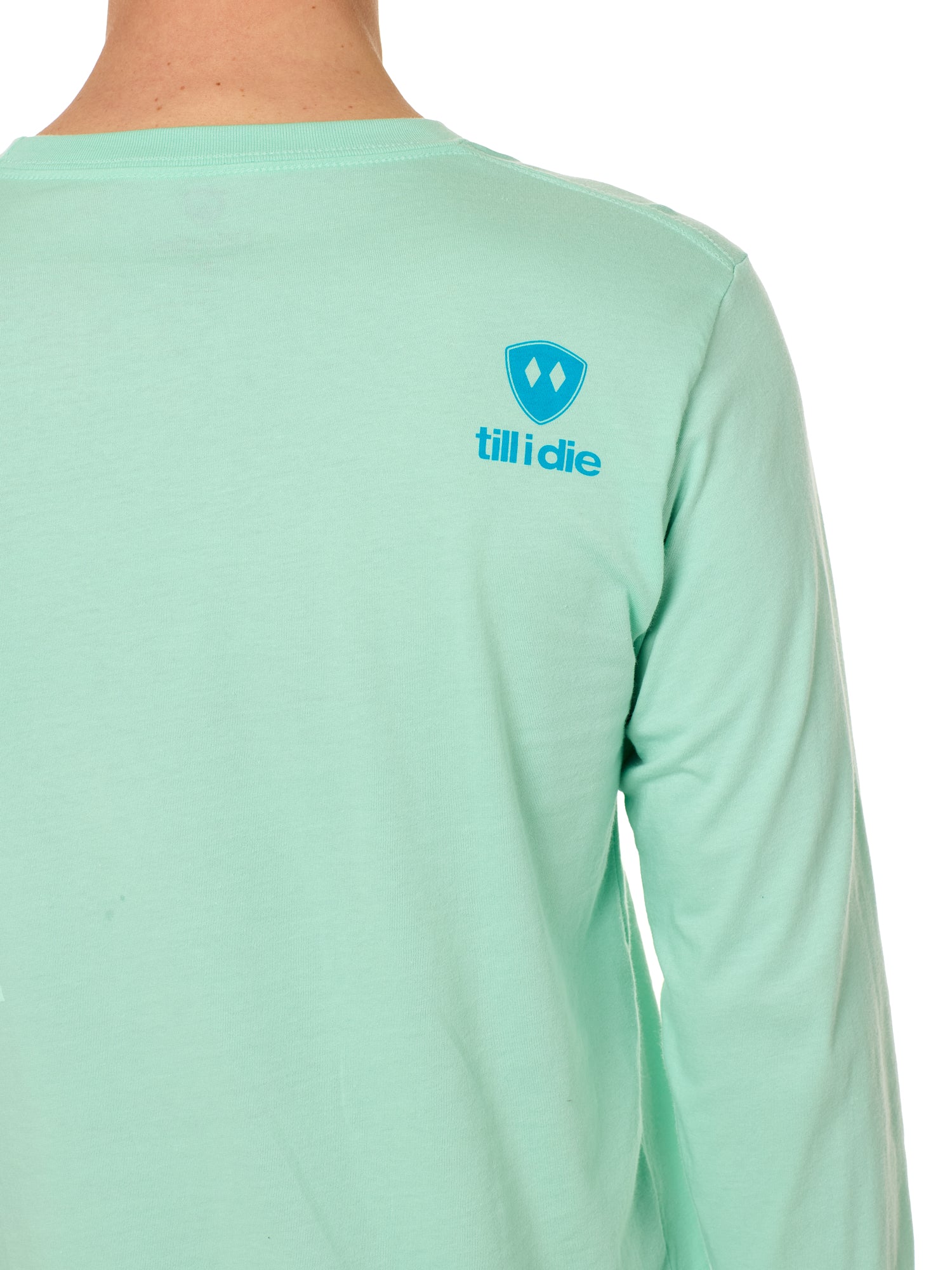 Back view of a male model wearing a Mint Green long sleeve shirt on a white background, featuring a blue Till I Die logo on the wearer’s top right shoulder.