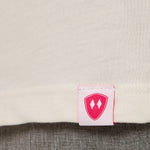 Close-up detail of a pink Double Diamond Shield woven hem label on a vintage white crew neck tee.
