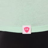 Close-up detail of a pink Double Diamond Shield woven hem label on a mint green v neck shirt.