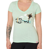 Front view of a female model wearing the Hammock V-neck tee in mint, displayed on a white background. The graphic depicts a vintage VW bus parked on a beach, with a surfboard leaning against it and a silhouetted figure relaxing in a hammock strung between the van and a palm tree.