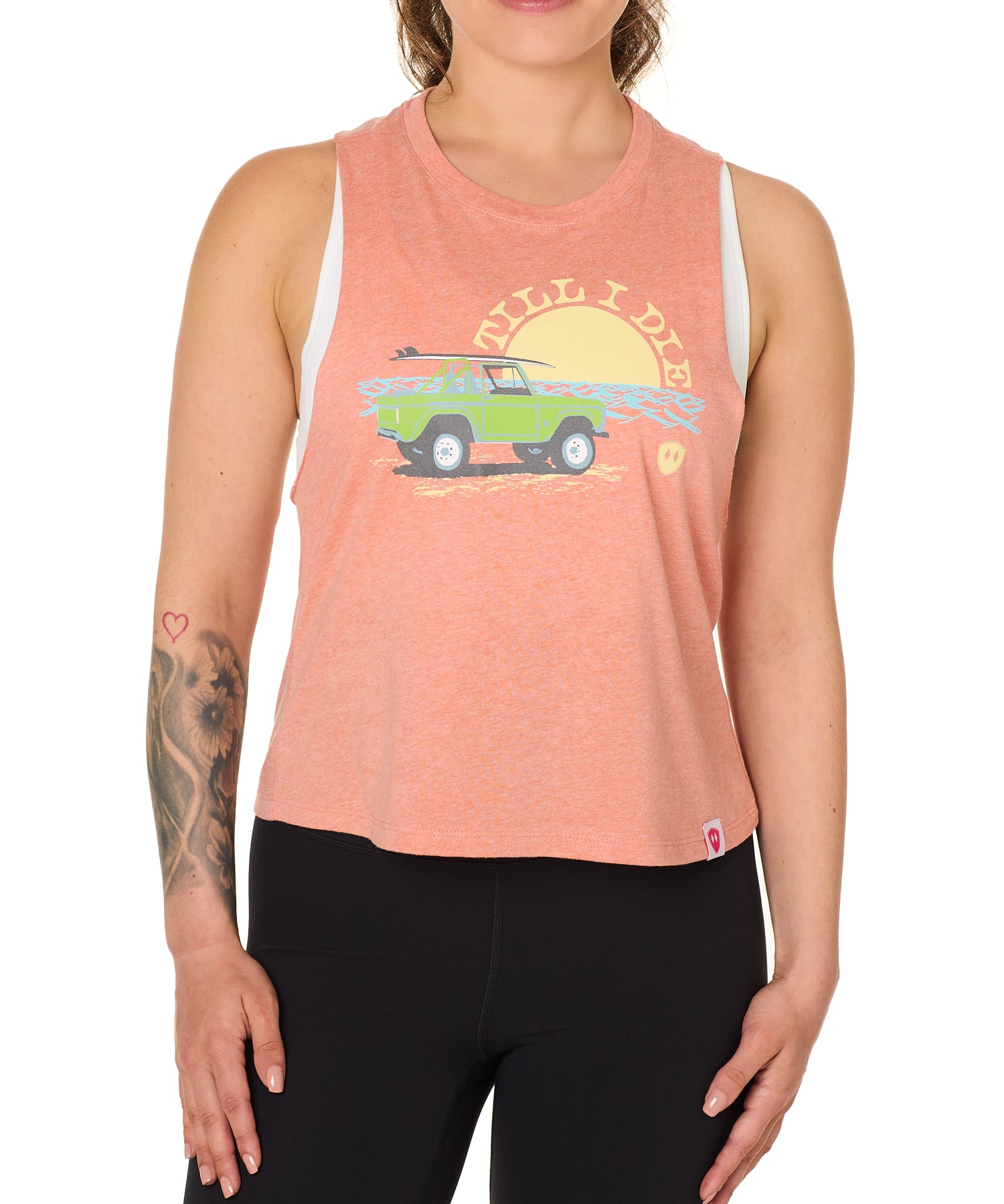 Front view of a female model wearing the Surf Truck tank in Sunset on a white background. The graphic features a classic green Bronco with a surfboard on the roof, parked in front of an ocean sunset, arched by “Till I Die” text.