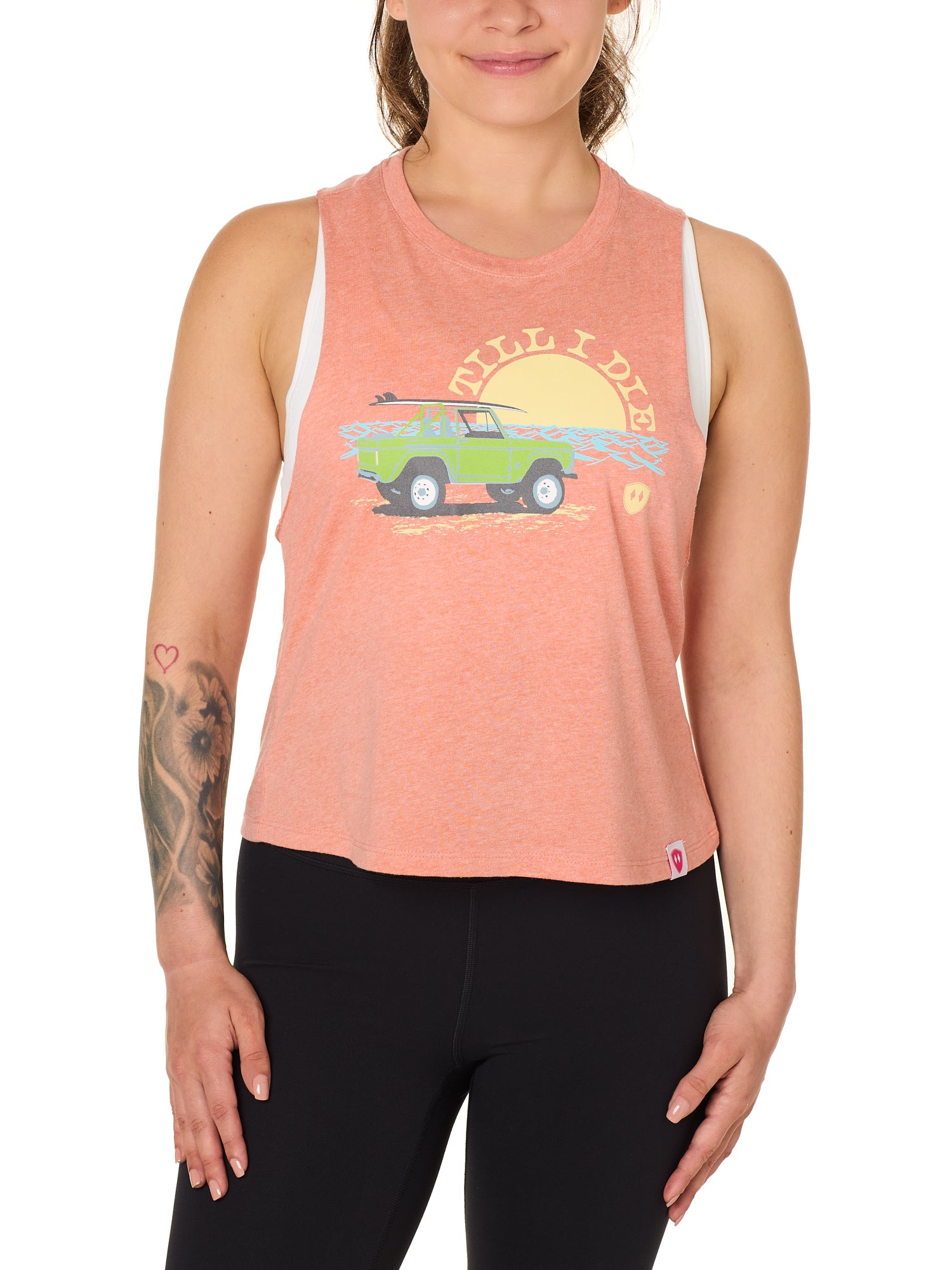 Front view of a female model wearing the Surf Truck tank in Sunset on a white background. The graphic features a classic green Bronco with a surfboard on the roof, parked in front of an ocean sunset, arched by “Till I Die” text.