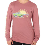 Front view of a female model wearing the Surf Truck long sleeve tee in deep sunset on a white background. The graphic features a classic green Bronco with a surfboard on the roof, parked in front of an ocean sunset, arched by “Till I Die” text.