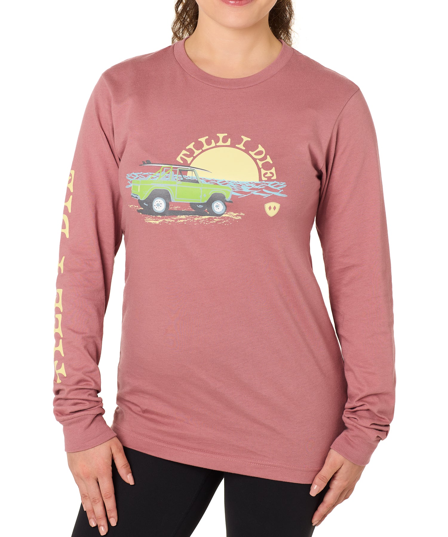 Front view of a female model wearing the Surf Truck long sleeve tee in deep sunset on a white background. The graphic features a classic green Bronco with a surfboard on the roof, parked in front of an ocean sunset, arched by “Till I Die” text.