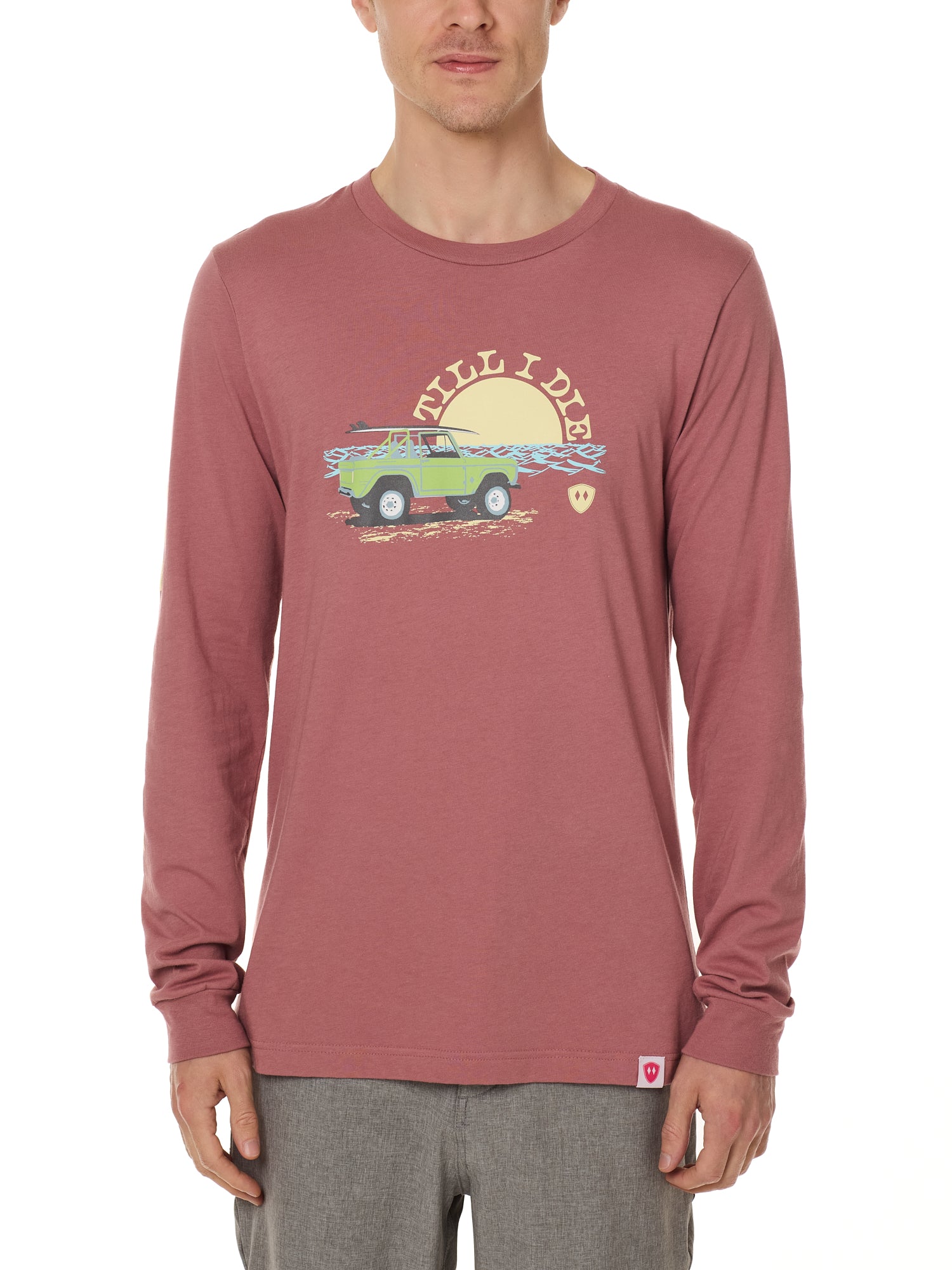 Front view of a male model wearing the Surf Truck long sleeve tee in deep sunset on a white background. The graphic features a classic green Bronco with a surfboard on the roof, parked in front of an ocean sunset, arched by “Till I Die” text.