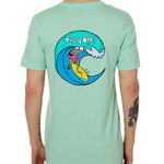 Back view of a male model wearing the Surfer Skeleton tee in mint green on a white background. The graphic features a multicolored circular graphic of a skeleton surfing a wave, with “Till I Die” text at the top.