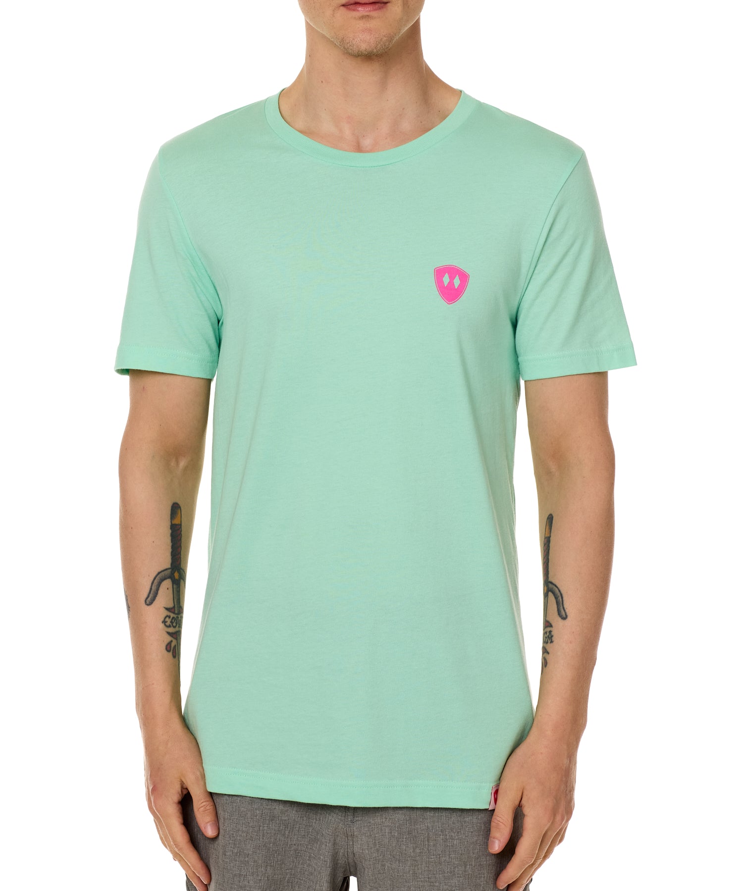 Front view of a male model wearing the Surfer Skeleton performance crew neck tee in mint green on a white background. Accented with a hot pink double diamond shield over wearers left chest.