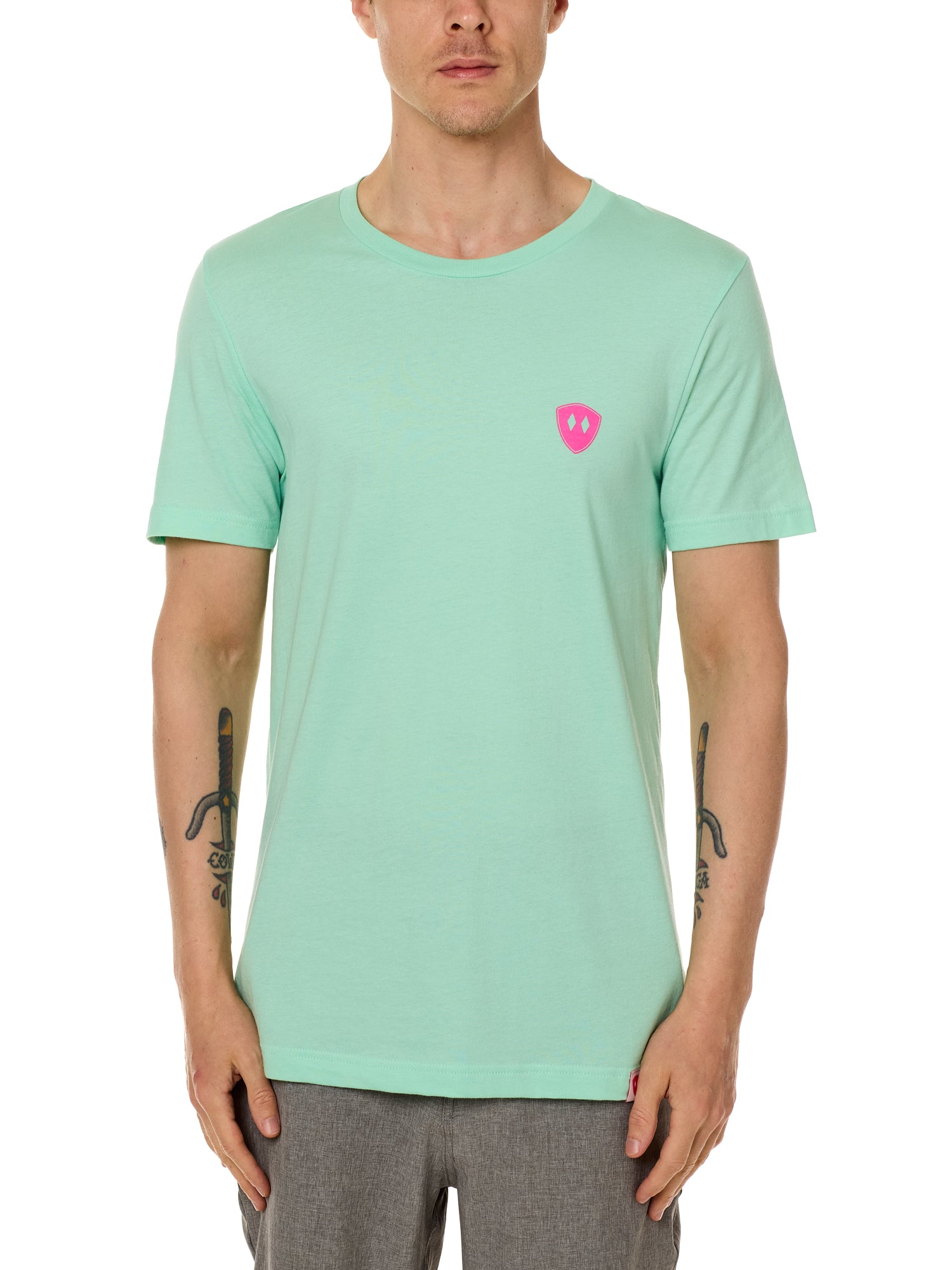 Front view of a male model wearing the Surfer Skeleton performance crew neck tee in mint green on a white background. Accented with a hot pink double diamond shield over wearers left chest.