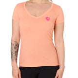 Front view of a female model wearing the Surfer Skeleton V neck tee in citrus on a white background. Accented with a hot pink double diamond shield over wearers left chest.