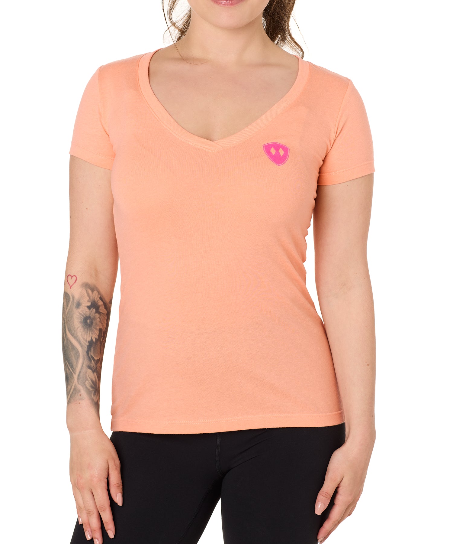 Front view of a female model wearing the Surfer Skeleton V neck tee in citrus on a white background. Accented with a hot pink double diamond shield over wearers left chest.
