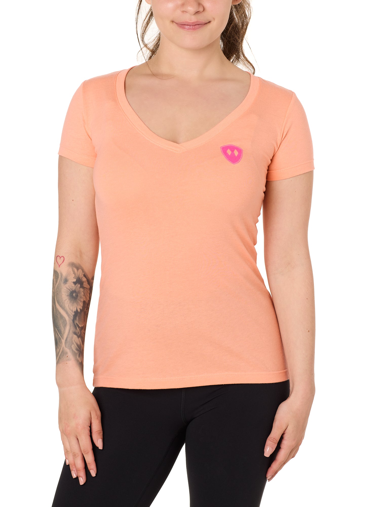 Front view of a female model wearing the Surfer Skeleton V neck tee in citrus on a white background. Accented with a hot pink double diamond shield over wearers left chest.