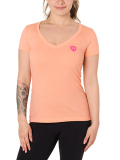 Front view of a female model wearing the Surfer Skeleton V neck tee in citrus on a white background. Accented with a hot pink double diamond shield over wearers left chest.