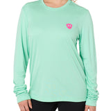 Front view of a female model wearing the Surfer Skeleton performance long sleeve tee in mint green on a white background. Accented with a hot pink double diamond shield over wearers left chest.