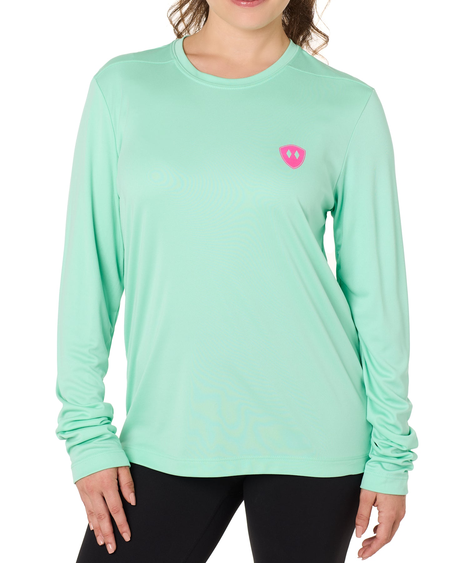 Front view of a female model wearing the Surfer Skeleton performance long sleeve tee in mint green on a white background. Accented with a hot pink double diamond shield over wearers left chest.
